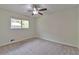 Neutral bedroom with a ceiling fan and natural light from the window overlooking the greenery outside at 5350 Rockbridge Rd, Stone Mountain, GA 30088