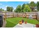 Fenced backyard with lawn and garden space, featuring a Buddha statue and small patio at 6322 Scudders Dr, Lithonia, GA 30058