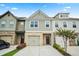 Charming townhome with three units, featuring a well-manicured lawn and individual driveways and garages at 6322 Scudders Dr, Lithonia, GA 30058