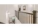 Upstairs hallway featuring hardwood floors, iron railing, and access to multiple rooms at 6322 Scudders Dr, Lithonia, GA 30058
