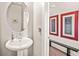 Stylish powder room with a pedestal sink and decorative wall art at 6322 Scudders Dr, Lithonia, GA 30058