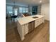 Modern kitchen open to the living area, featuring a large island with seating, stainless steel appliances, and ample storage at 251 Turner Ln, Woodstock, GA 30188