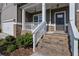 Inviting front entrance with brick steps and a covered porch at 5985 Hidden Ridge Ct, Cumming, GA 30028