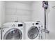 Laundry room with washer, dryer, wire rack shelf, and vacuum cleaner at 5985 Hidden Ridge Ct, Cumming, GA 30028