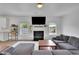 Bright living room with fireplace, comfortable sofa, and kitchen view at 5985 Hidden Ridge Ct, Cumming, GA 30028