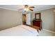 Bedroom with wooden dresser, patterned mirror, ceiling fan, and doorway that leads to the hallway at 2975 Oak Hampton Way, Duluth, GA 30096