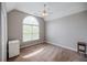 Neutral bedroom featuring an arched window, ceiling fan, and plush carpeting at 2975 Oak Hampton Way, Duluth, GA 30096
