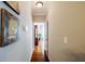Hallway featuring hardwood floors, neutral walls, and artwork with a view into another room at 2975 Oak Hampton Way, Duluth, GA 30096