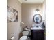 Elegant powder room with a dark wood vanity, a modern round mirror, and neutral paint at 2975 Oak Hampton Way, Duluth, GA 30096