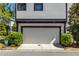 A modern home's garage door, accented by lush landscaping and a clean, paved driveway at 1014 Braeburn Ln, Decatur, GA 30030