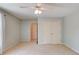 Spacious bedroom with carpet, neutral paint, and ceiling fan. Double door closet and doorway present at 12340 Preserve Ln, Alpharetta, GA 30005