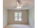 Well-lit bedroom with neutral walls, plush carpet, and ceiling fan, offering comfort and style at 12340 Preserve Ln, Alpharetta, GA 30005