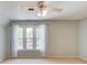 Bedroom with neutral paint, carpet, and windows. Curtains and ceiling fan are also present at 12340 Preserve Ln, Alpharetta, GA 30005