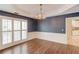 Spacious dining area boasts hardwood floors, decorative wainscoting, and ample natural light from shuttered windows at 12340 Preserve Ln, Alpharetta, GA 30005