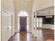 Bright foyer with tall ceilings, wood floors, columns, and an arched front door with side lights at 12340 Preserve Ln, Alpharetta, GA 30005