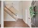 Inviting foyer with hardwood floors, staircase, white trim, and a view into the living area at 12340 Preserve Ln, Alpharetta, GA 30005
