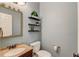 Cozy half bathroom features a stylish mirror, floating shelves with plants, and a classic pedestal sink at 12340 Preserve Ln, Alpharetta, GA 30005