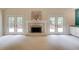 Bright living room with fireplace, French doors to the deck, and built-in cabinets at 12340 Preserve Ln, Alpharetta, GA 30005