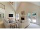 Staged living room features vaulted ceilings, fireplace, and access to outdoor deck at 12340 Preserve Ln, Alpharetta, GA 30005
