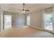 Airy main bedroom with tray ceiling, large windows, and a glimpse into an ensuite bathroom at 12340 Preserve Ln, Alpharetta, GA 30005
