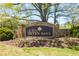 Stone entrance to Seven Oaks community, featuring beautifully landscaped signage and vibrant flowering plants at 12340 Preserve Ln, Alpharetta, GA 30005