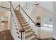 View of the carpeted staircase, wood railing and balusters, and open floor plan with fireplace, french doors, and kitchen at 12340 Preserve Ln, Alpharetta, GA 30005