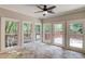 Bright sun room with ceiling fan overlooking a tranquil wooded backyard at 12340 Preserve Ln, Alpharetta, GA 30005