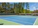 Well-maintained community tennis court featuring a vibrant blue surface and green surround at 12340 Preserve Ln, Alpharetta, GA 30005