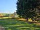 Fenced backyard featuring a lush lawn and mature trees offering shade and privacy at 1424 Belmont Rd, Villa Rica, GA 30180