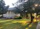Lovely backyard with mature trees, a small fenced area, and the home's elevated patio in the background at 1424 Belmont Rd, Villa Rica, GA 30180