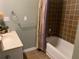 Compact bathroom features a combination tub and shower with brown tiled walls at 1424 Belmont Rd, Villa Rica, GA 30180