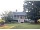 Charming home featuring a full front porch, a well-manicured lawn, and mature landscaping at 1424 Belmont Rd, Villa Rica, GA 30180