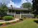 Charming home featuring a full front porch, a well-manicured lawn, and mature landscaping at 1424 Belmont Rd, Villa Rica, GA 30180