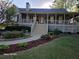 Charming home featuring a welcoming front porch, landscaped garden beds, and inviting curb appeal at 1424 Belmont Rd, Villa Rica, GA 30180