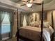 Spacious bedroom featuring a four-poster bed, soft lighting, and window with flowing curtains at 1424 Belmont Rd, Villa Rica, GA 30180