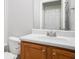 Bathroom with a white sink, wooden cabinet, and a mirror with vanity lighting at 210 Arbor Creek Dr, Dallas, GA 30157