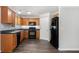 Well-lit kitchen with stainless steel appliances, hardwood cabinets, and dark countertop at 210 Arbor Creek Dr, Dallas, GA 30157