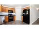 Spacious kitchen featuring wood cabinets, black appliances, and neutral wall color at 210 Arbor Creek Dr, Dallas, GA 30157