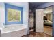 Tranquil tub with a window view, complemented by a glimpse into the adjacent bedroom at 6904 Estepona St, Atlanta, GA 30349