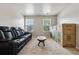 Bonus room is furnished with a plush black leather sofa at 6904 Estepona St, Atlanta, GA 30349