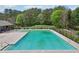 View of a sparkling community pool with metal railings, surrounded by a fence and greenery at 6904 Estepona St, Atlanta, GA 30349