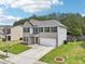 Charming two-story home with brick and siding exterior, a well-manicured lawn, and an attached two-car garage at 6904 Estepona St, Atlanta, GA 30349