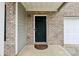 A close up view of the home's front door, set in a brick facade at 6904 Estepona St, Atlanta, GA 30349