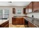 Kitchen with a view: Features dark wood cabinetry and sink with a window overlooking the yard at 6904 Estepona St, Atlanta, GA 30349