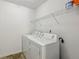 Bright laundry area with a washer, dryer, and wire shelving for convenient storage at 6904 Estepona St, Atlanta, GA 30349