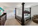 Primary bedroom with a four-poster bed, dresser, and comfortable seating area, offers a tranquil retreat at 6904 Estepona St, Atlanta, GA 30349