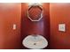 Stylish half-bathroom features an ornate mirror and red wall, adding character to the space at 6904 Estepona St, Atlanta, GA 30349