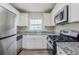 Modern kitchen with stainless steel appliances, white cabinets, and granite countertops at 2910 Diana Sw Dr, Atlanta, GA 30315