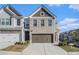 Attractive townhome with two-car garage, brick accents, and well-maintained landscaping at 7676 Viking Rd, Fairburn, GA 30213