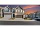 Beautiful townhome with a two-car garage and charming brick and siding exterior during sunset at 7676 Viking Rd, Fairburn, GA 30213